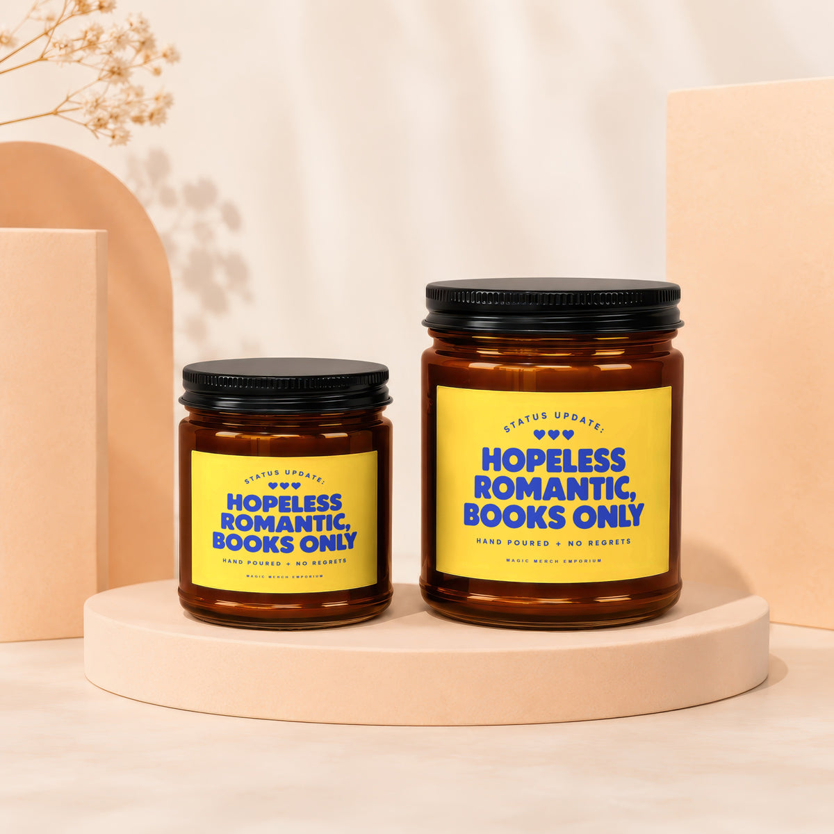 Two amber glass candles with yellow labels reading "Hopeless Romantic, Books Only".