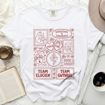 White t-shirt with red graphic of stamps, fox, birds, hearts, dagger, and text.