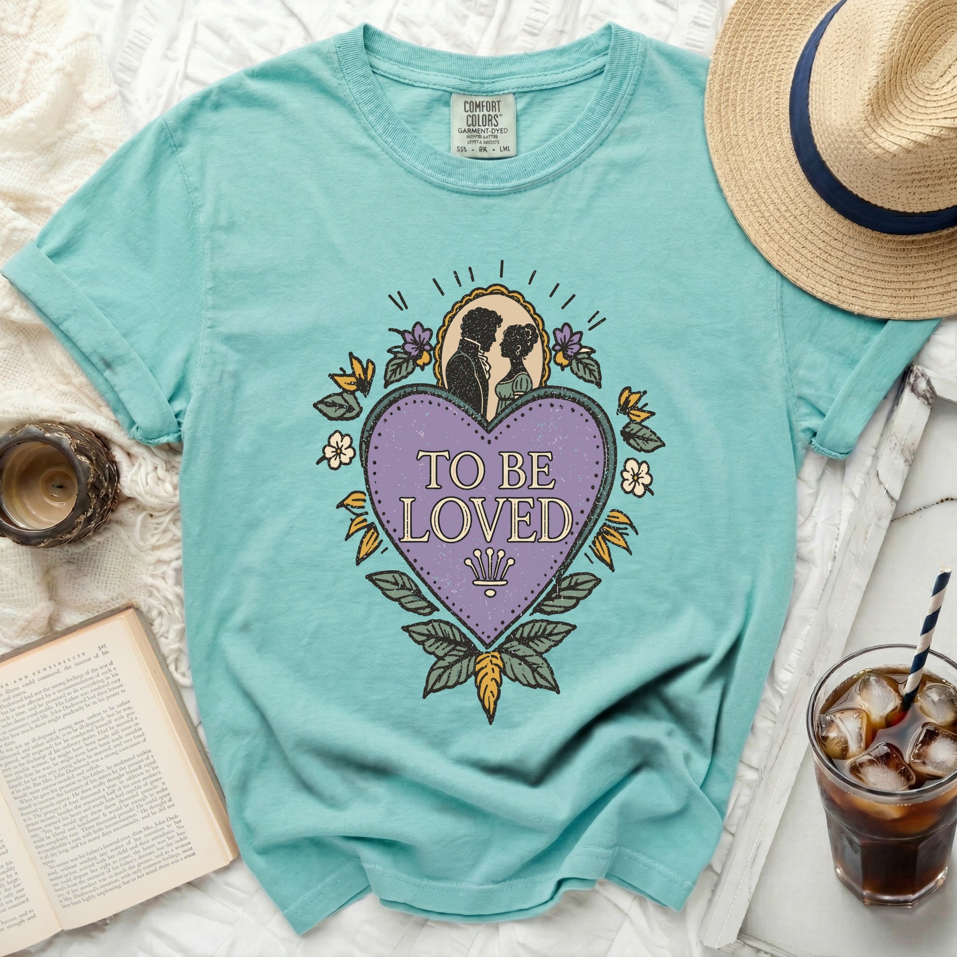 Teal t-shirt with "TO BE LOVED" graphic featuring silhouettes and heart.