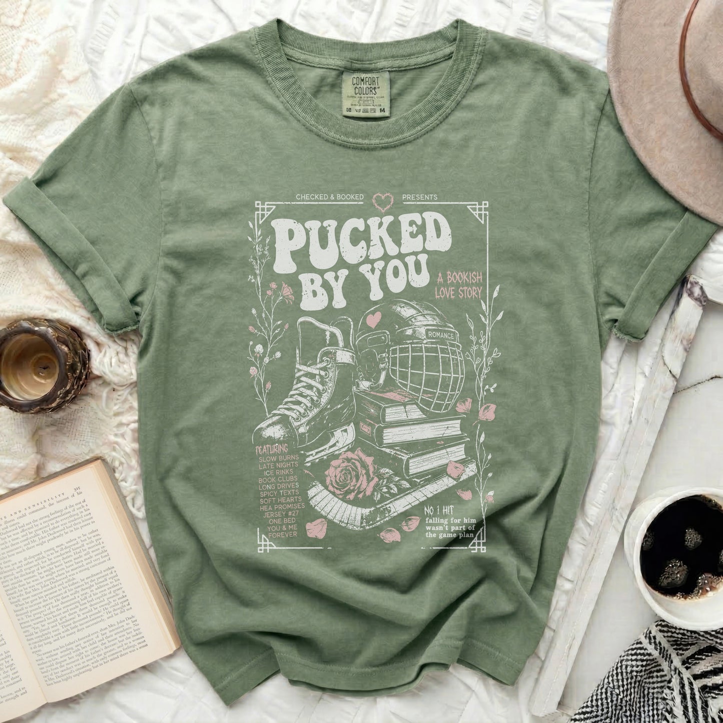 Green t-shirt with "Pucked by You" bookish romance graphic and text.