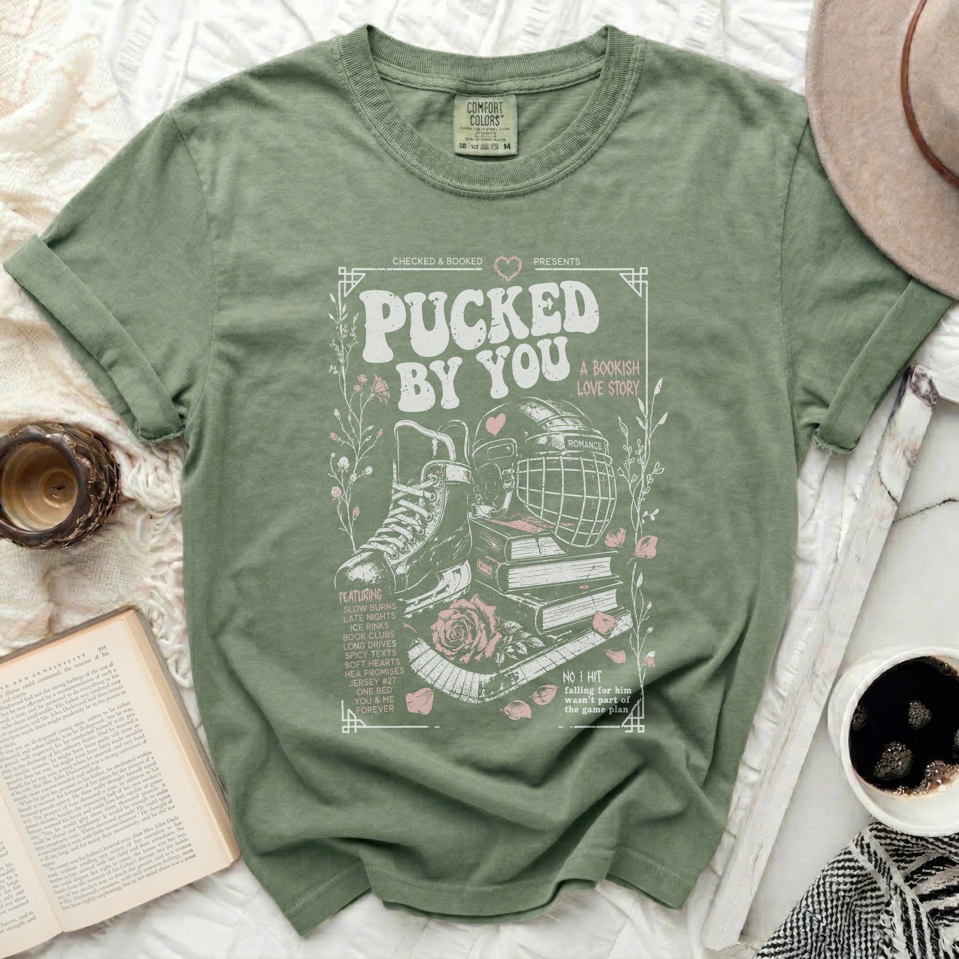 Green t-shirt with "Pucked by You" bookish romance graphic and text.