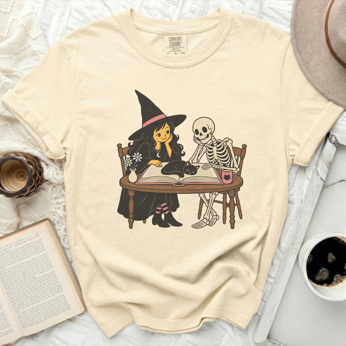 Witch, skeleton, and cat reading a book together.