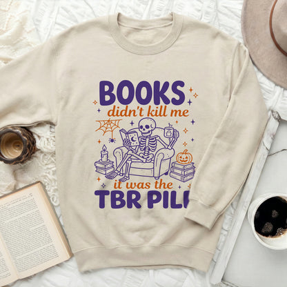 Light crewneck sweatshirt with purple and orange text and skeleton graphic.