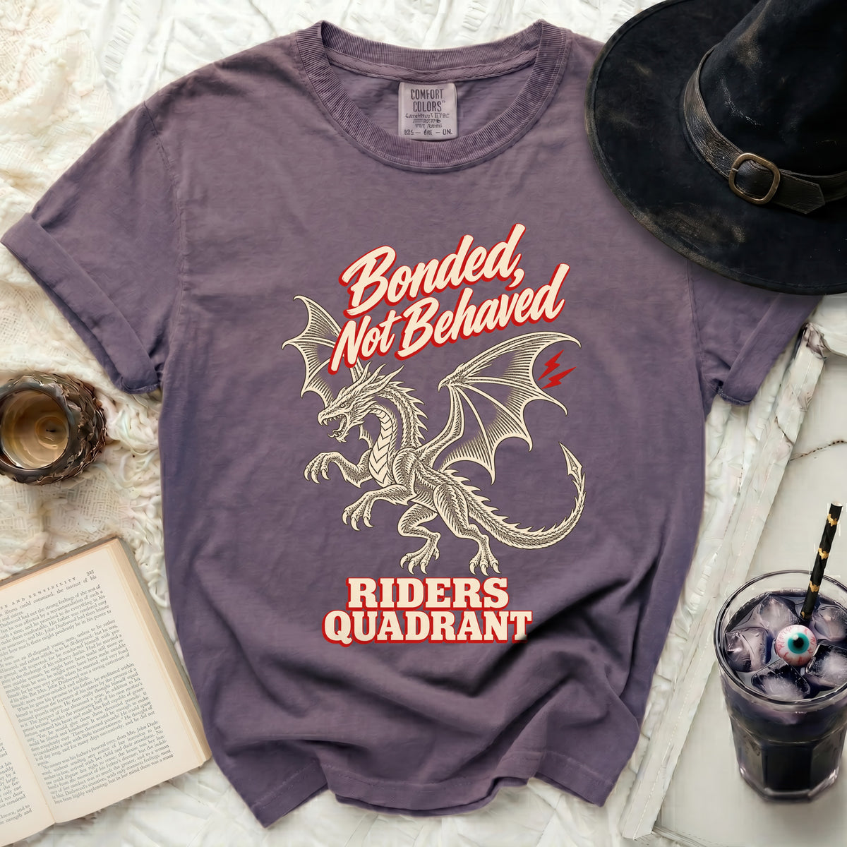 Purple t-shirt with dragon graphic and text "Bonded, Not Behaved RIDERS QUADRANT".