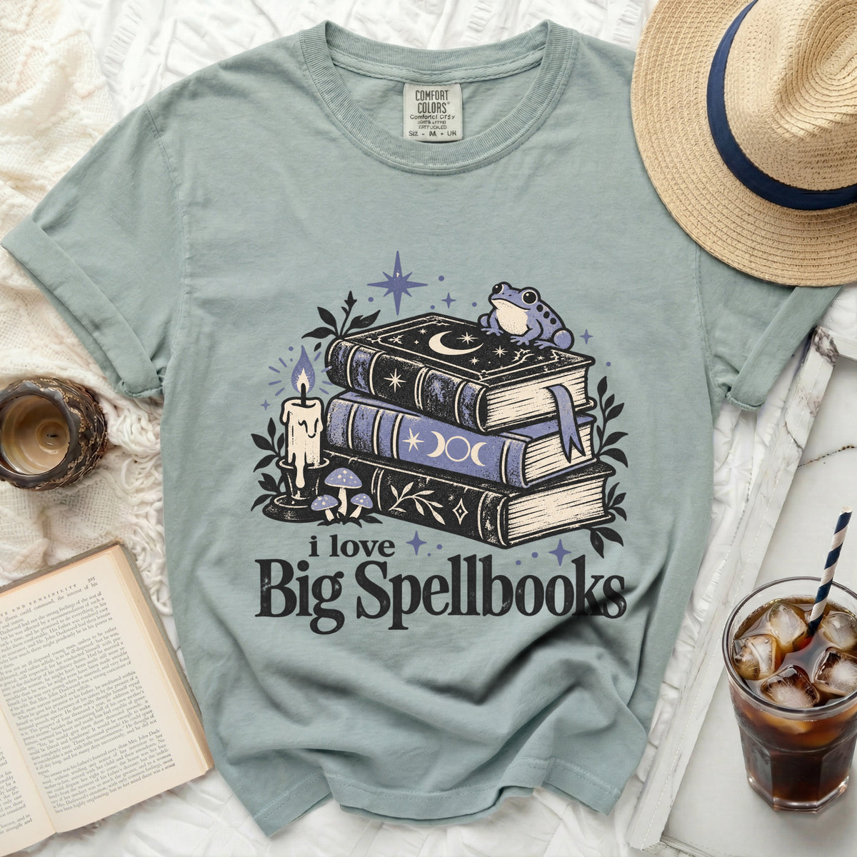 Teal t-shirt with "i love Big Spellbooks" text and whimsical book illustration.