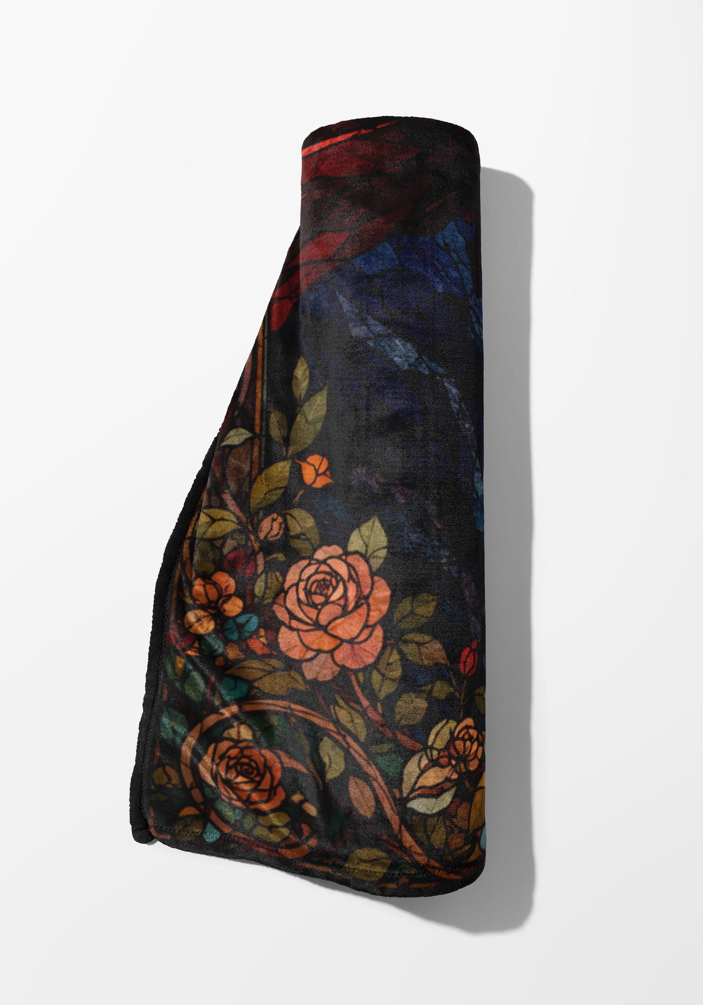 Rolled plush blanket with a dark floral and rose pattern in stained glass style.