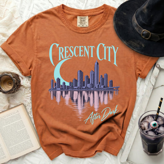 Orange t-shirt with "Crescent City" text and city skyline graphic.