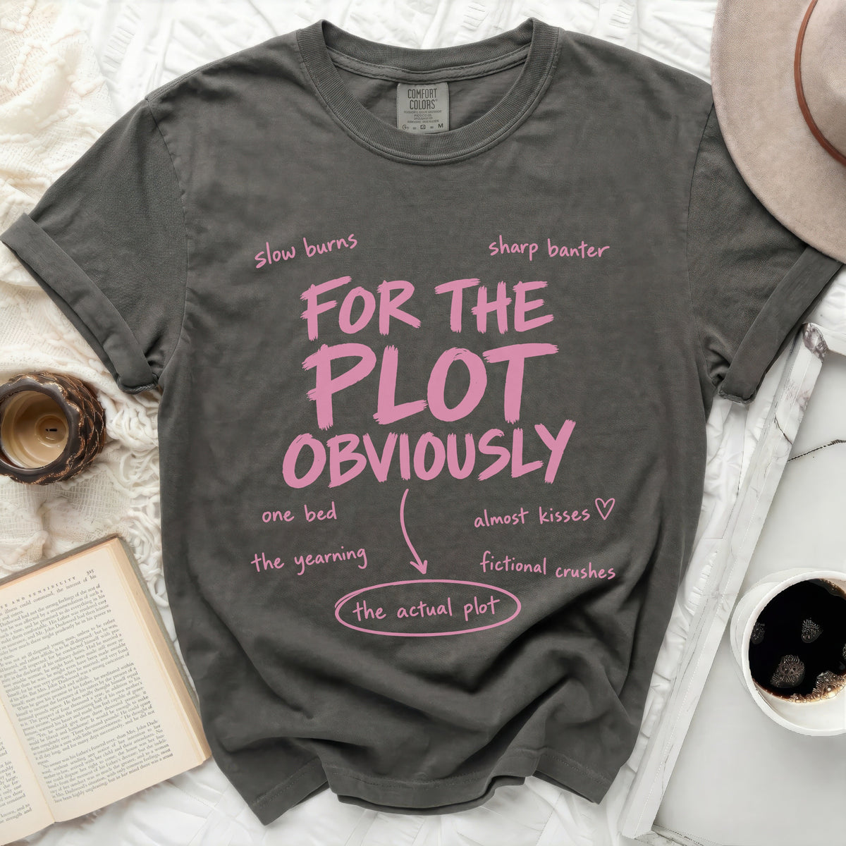 Dark grey t-shirt with pink text "FOR THE PLOT OBVIOUSLY" and related phrases.