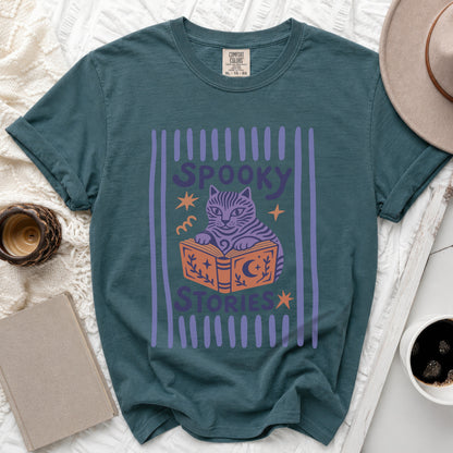Teal t-shirt with graphic of a cat reading a book, saying "Spooky Stories".