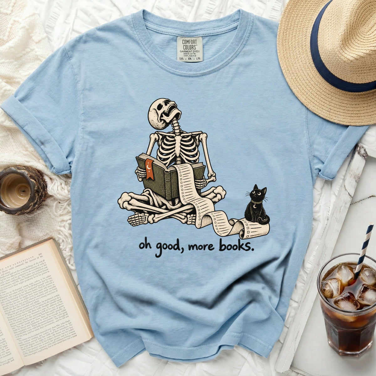 Light blue t-shirt with skeleton reading a long scroll and a black cat.
