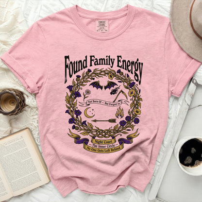 Pink t-shirt with "Found Family Energy" text and a circular floral design.