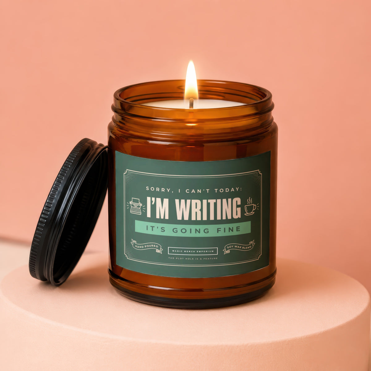 Amber jar candle with lid off, lit wick, and a label saying "I'm Writing".
