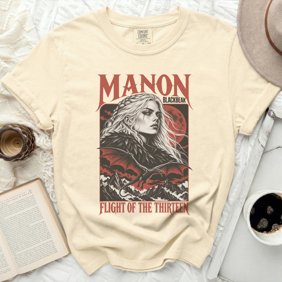 Cream t-shirt with "Manon Blackbeak Flight of the Thirteen" graphic featuring a woman and dragon.
