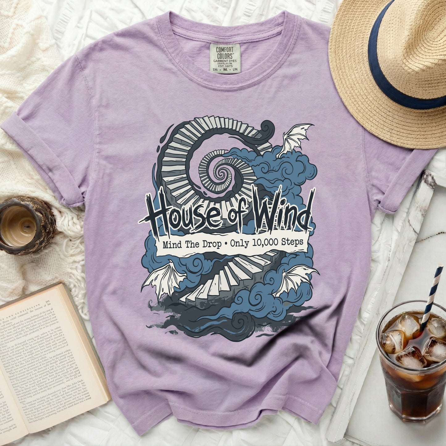 Purple t-shirt with "House of Wind" text and spiral stairs graphic.