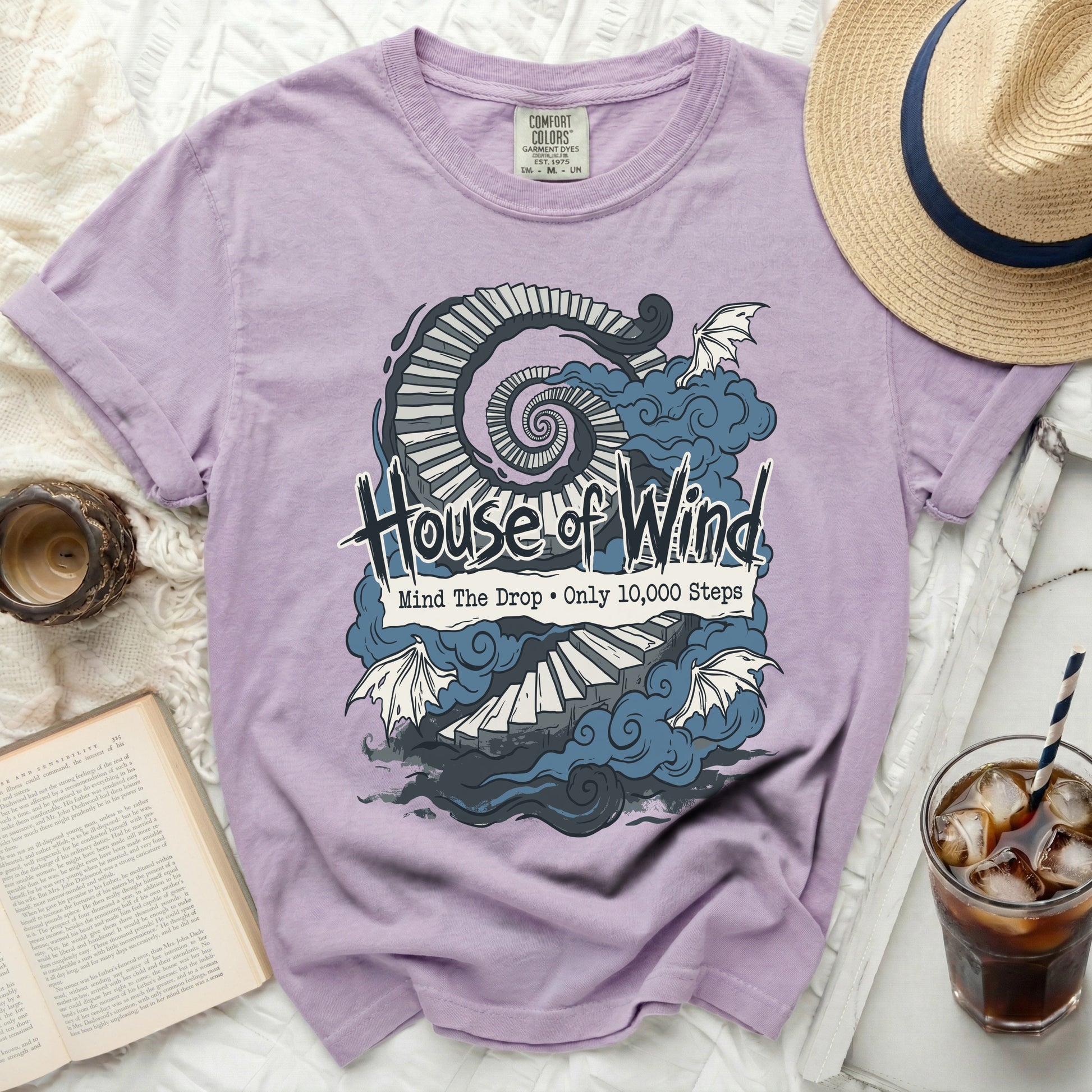 Purple t-shirt with "House of Wind" text and spiral stairs graphic.