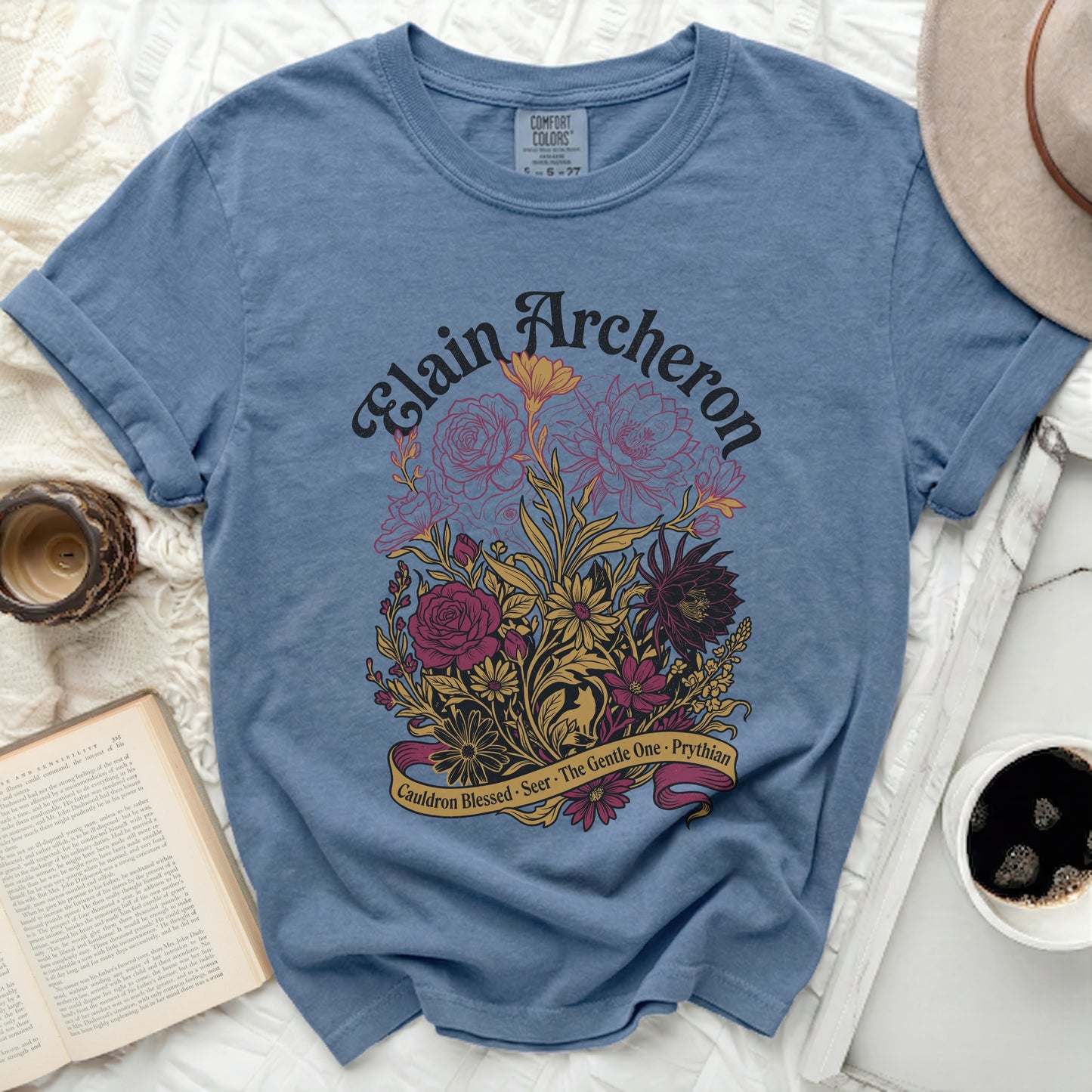 Blue t-shirt with Elain Archeron floral design and banner text.