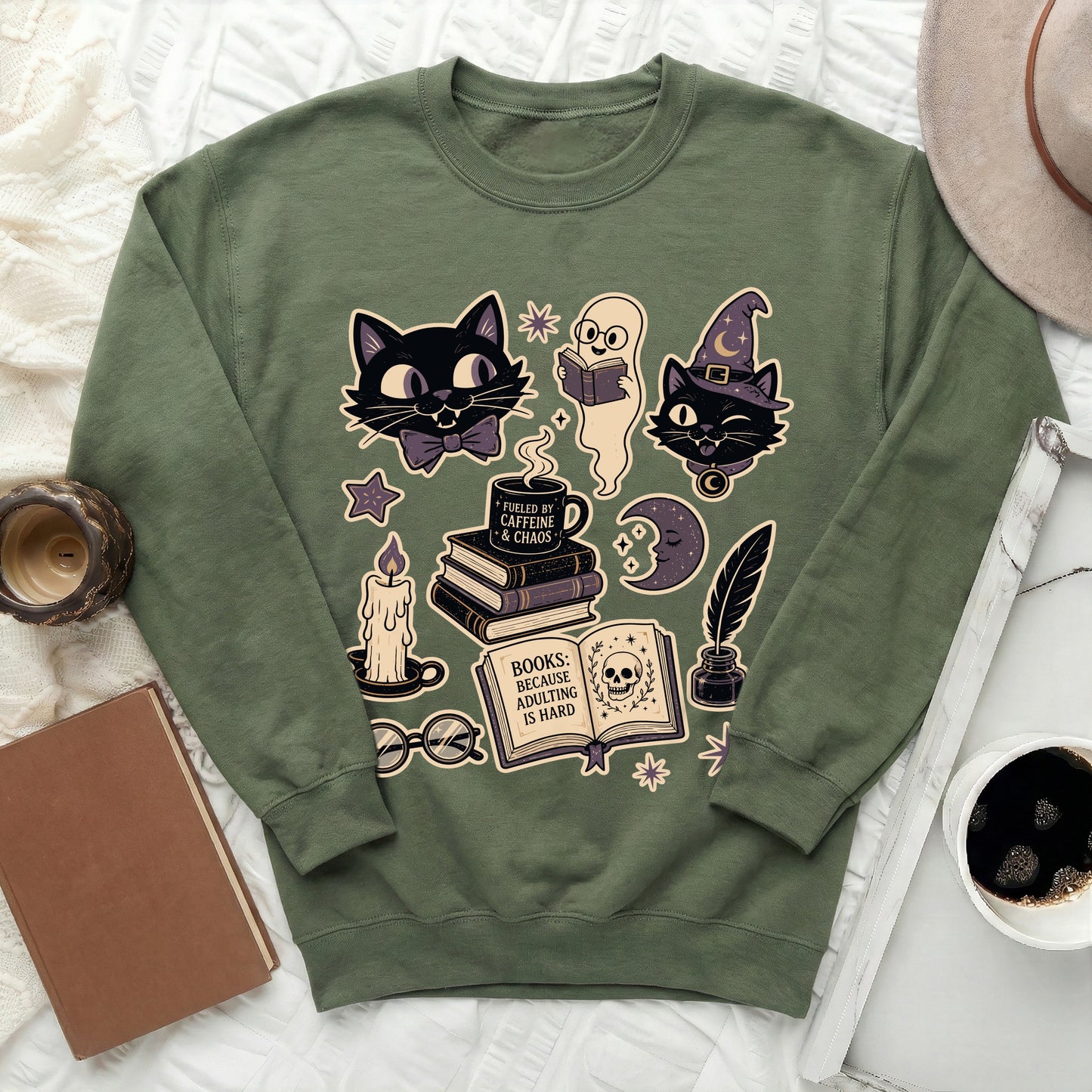 Green sweatshirt with black cats, ghost, books, candle, and skull graphic.