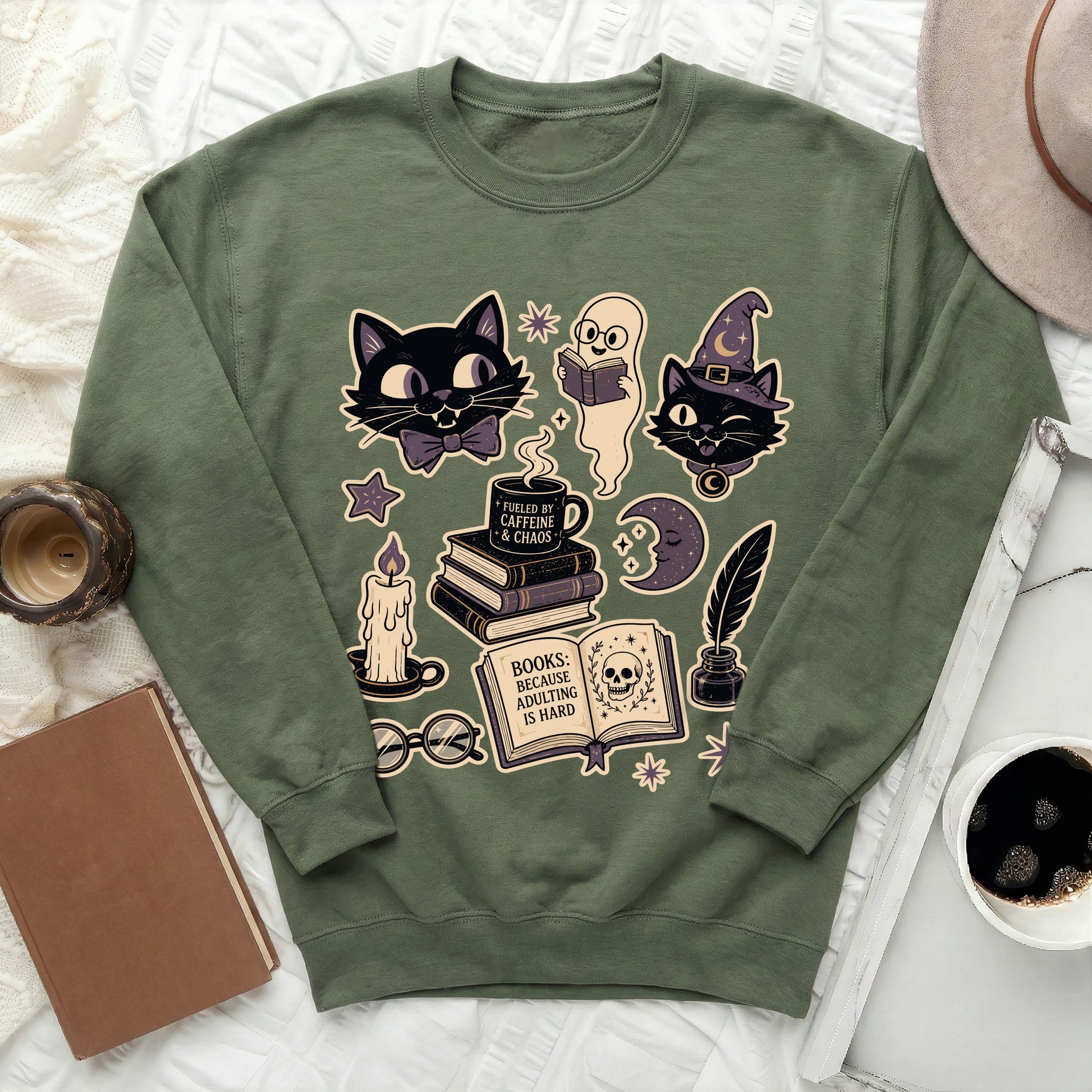 Green sweatshirt with black cats, ghost, books, candle, and skull graphic.