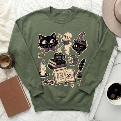 Green sweatshirt with black cats, ghost, books, candle, and skull graphic.