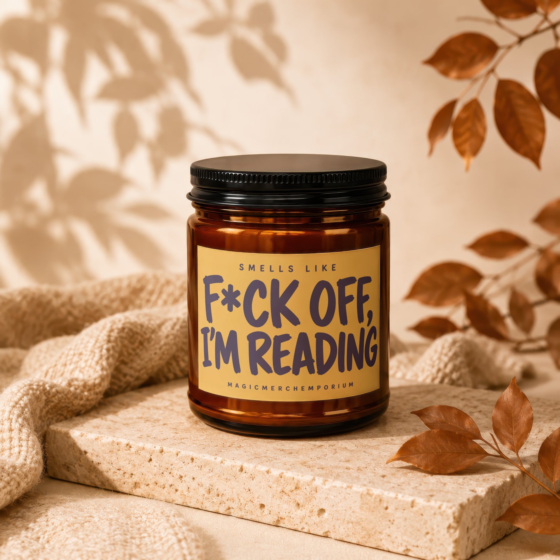 Brown candle with black lid on stone, text reads: "F*CK OFF, I'M READING".