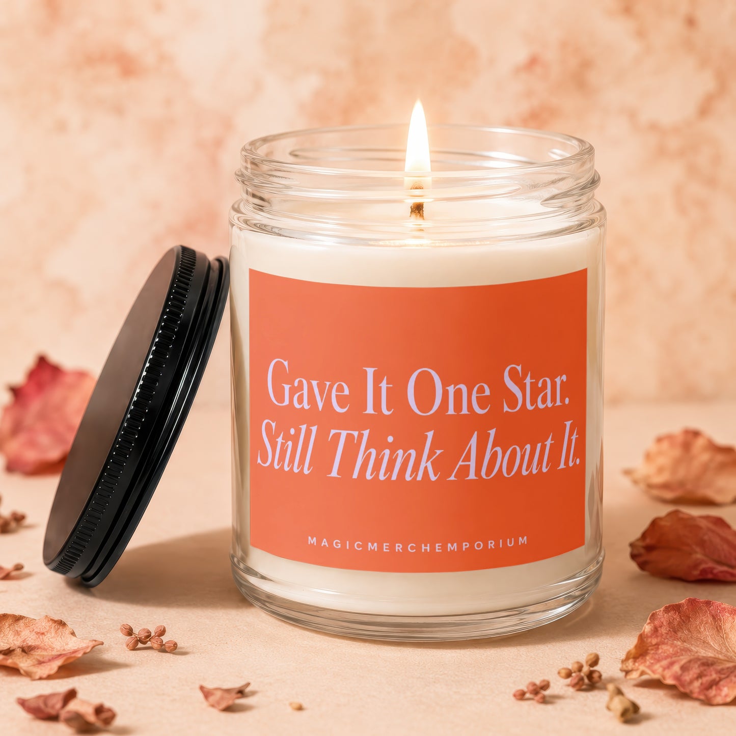 Candle with orange label reading "Gave It One Star. Still Think About It."
