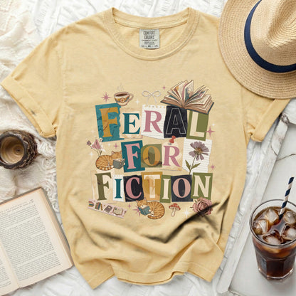 Yellow t-shirt with "Feral for Fiction" graphic and reading cats.