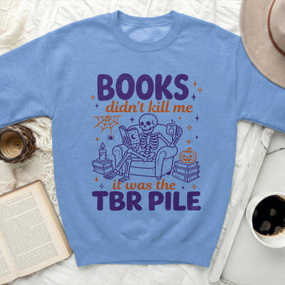 Skeleton sitting in chair reading and drinking "Books didn't kill me it was the TBR pile".