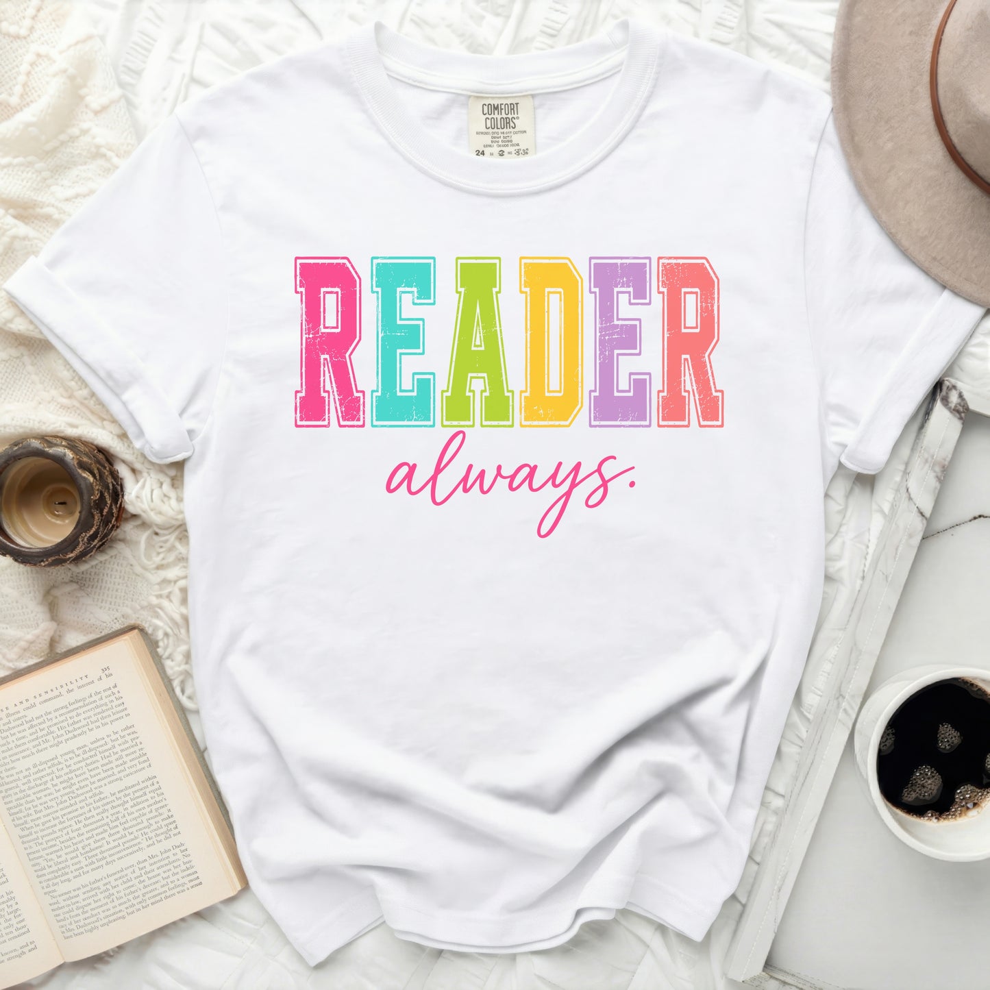 White Comfort Colors t-shirt with "READER always." in colorful block letters.