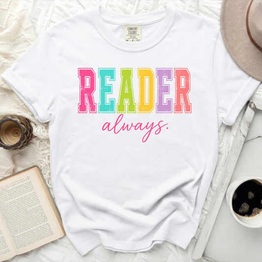White Comfort Colors t-shirt with "READER always." in colorful block letters.