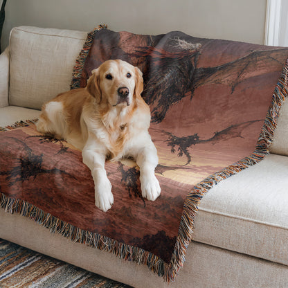 A golden retriever dog is lying on a couch with a dragon-themed blanket.