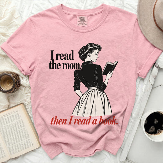 Pink t-shirt with "I read the room. then I read a book." text and illustration.