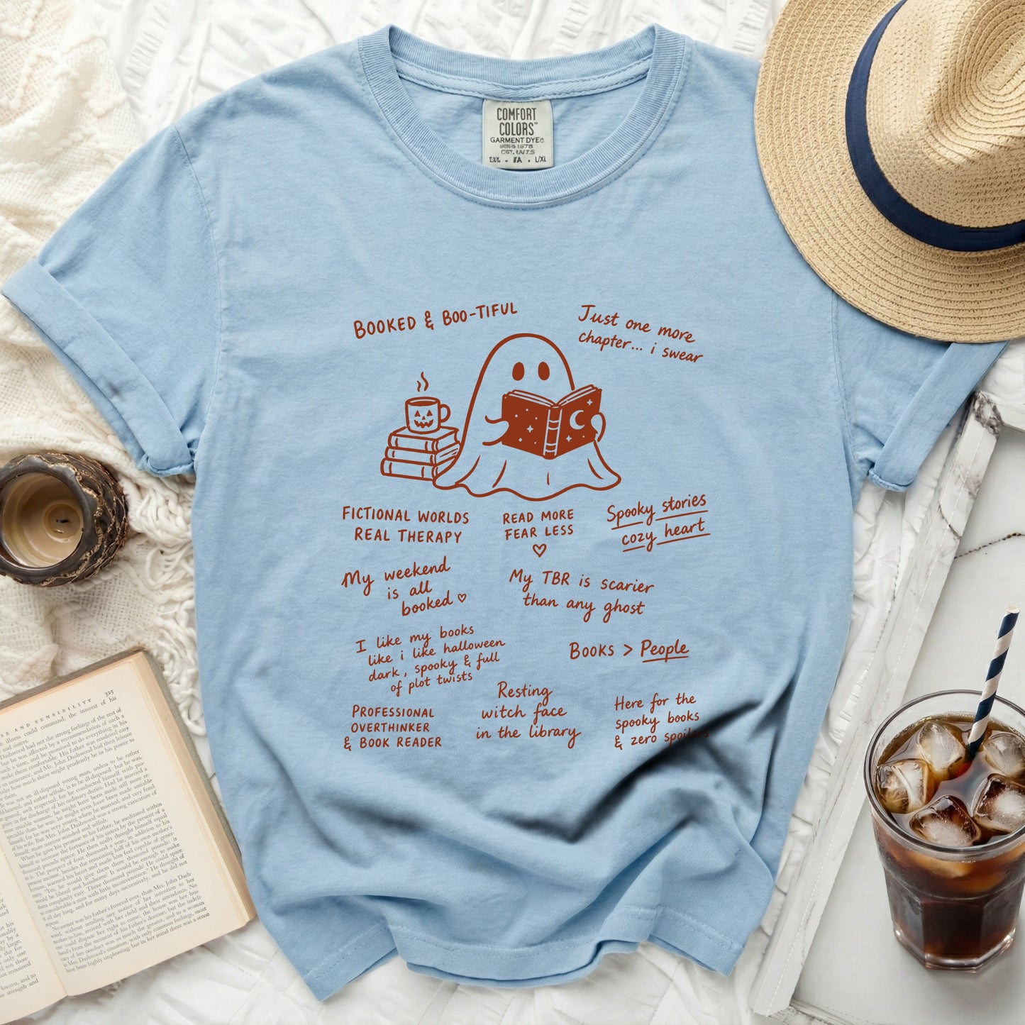 Light blue comfort colors t-shirt with ghost reading a book and book-themed text.
