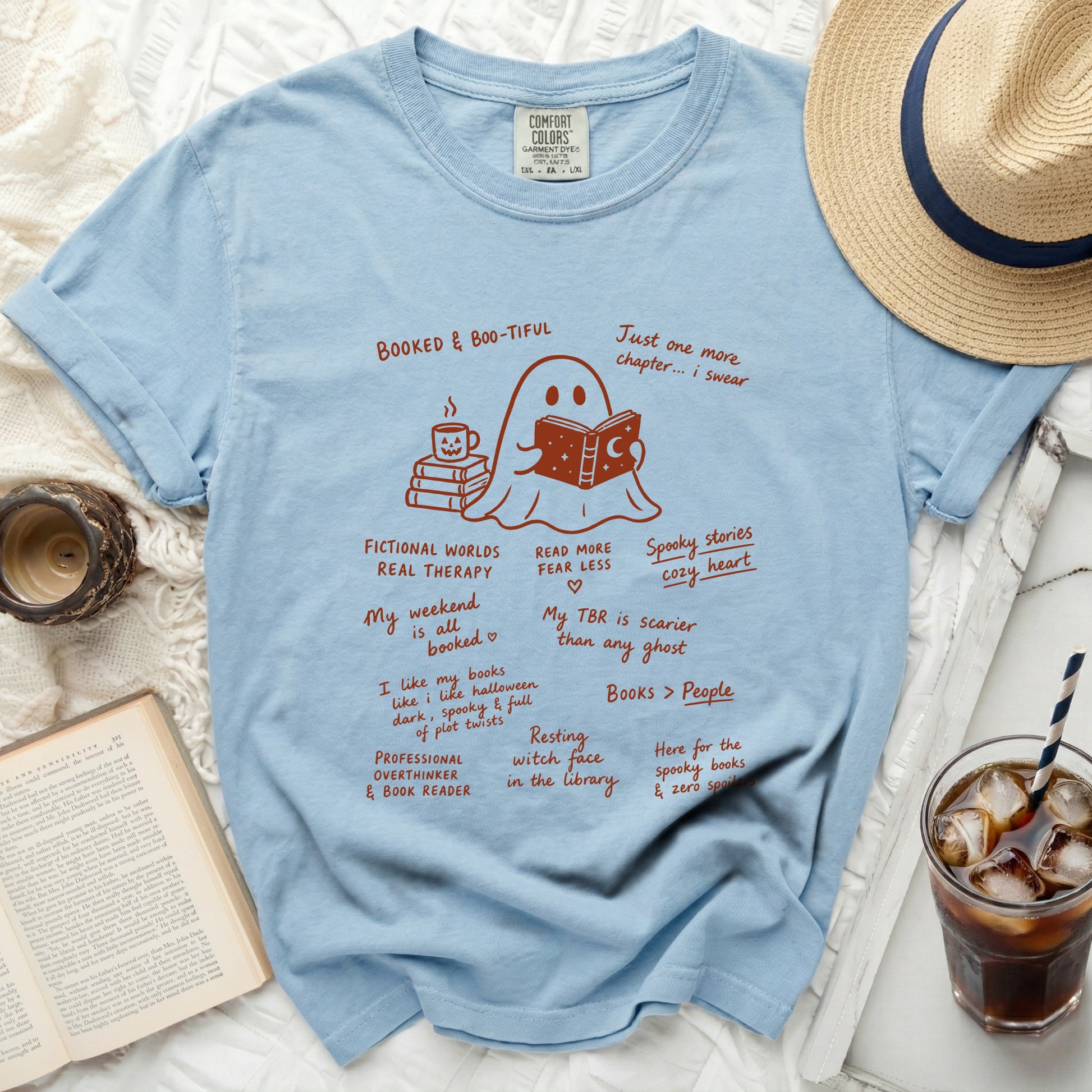 Light blue comfort colors t-shirt with ghost reading a book and book-themed text.
