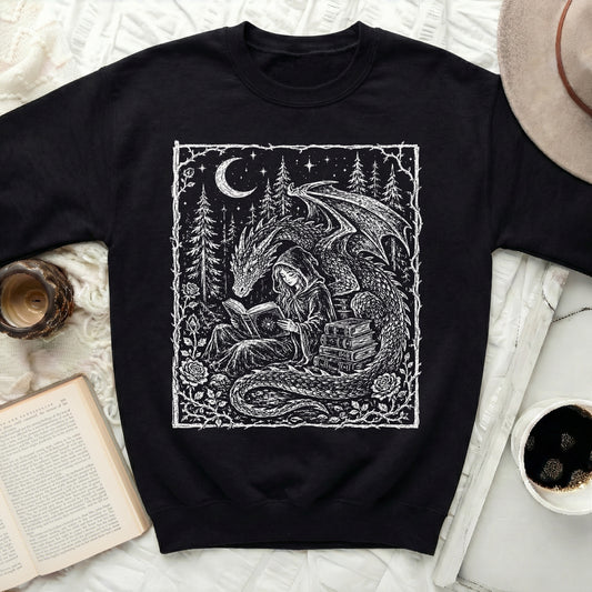 Black sweatshirt with white graphic of a dragon and a hooded figure reading a book.