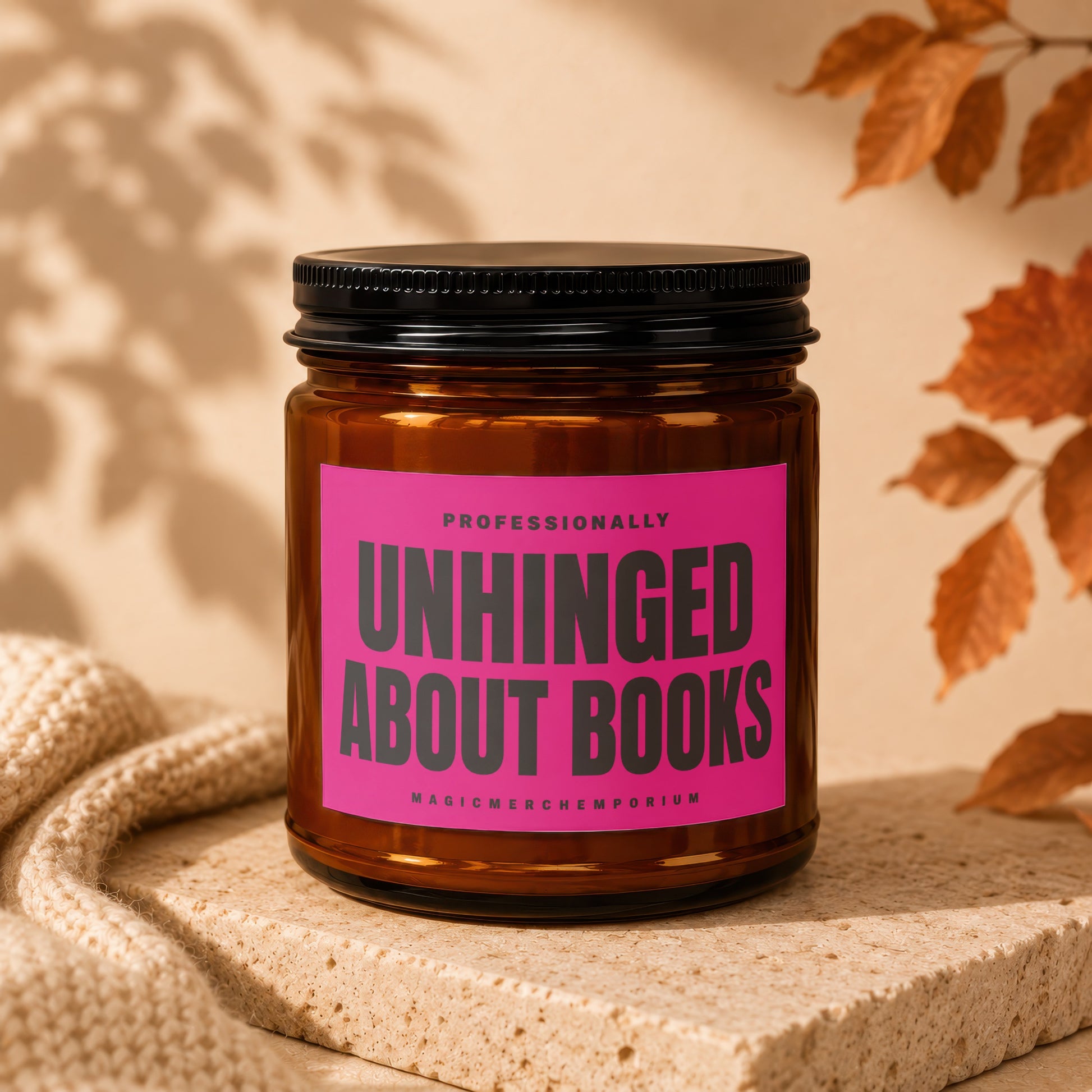 Brown candle in jar with pink label reading "Unhinged About Books."