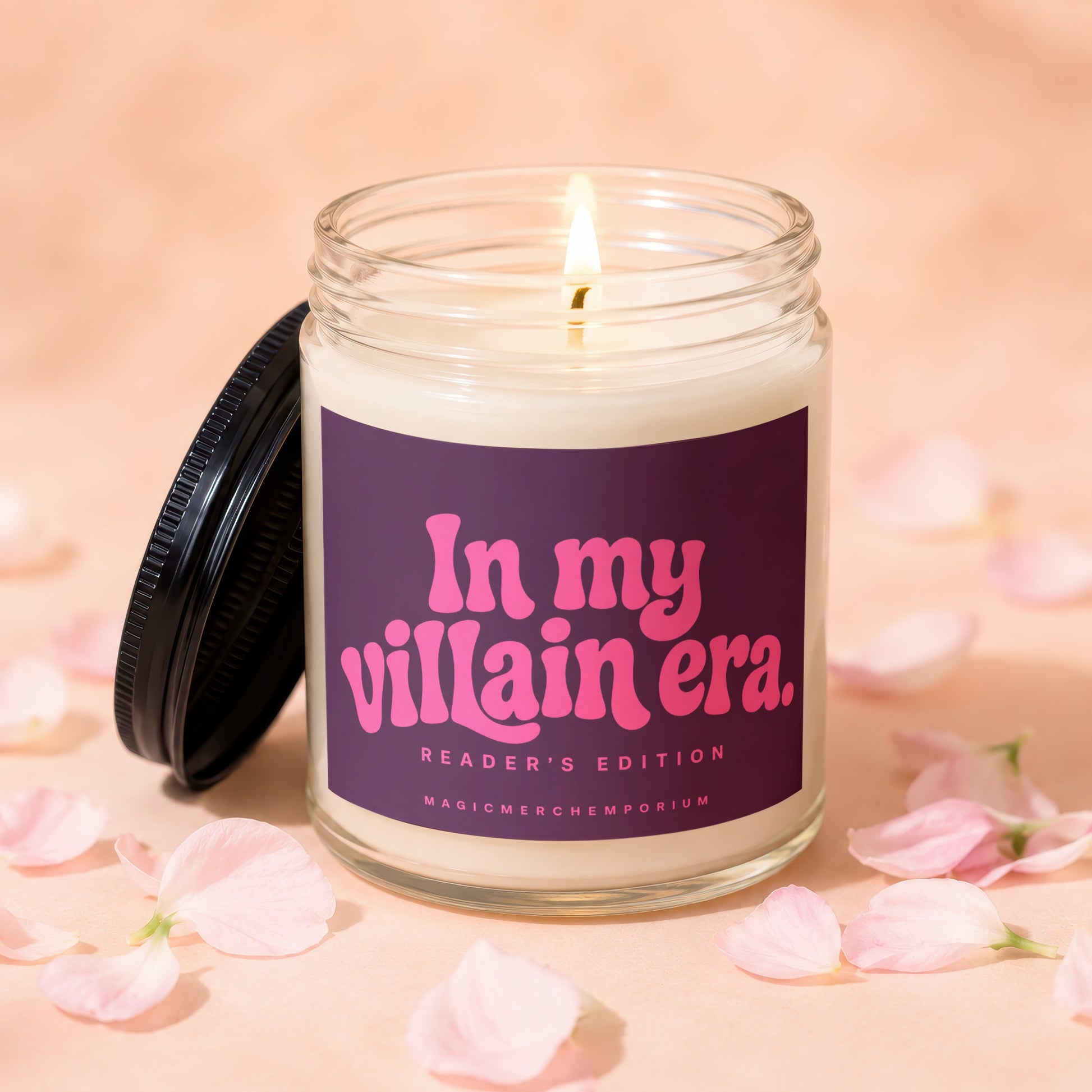 Glass candle with lit wick, purple label reads "In my villain era. Reader's Edition".