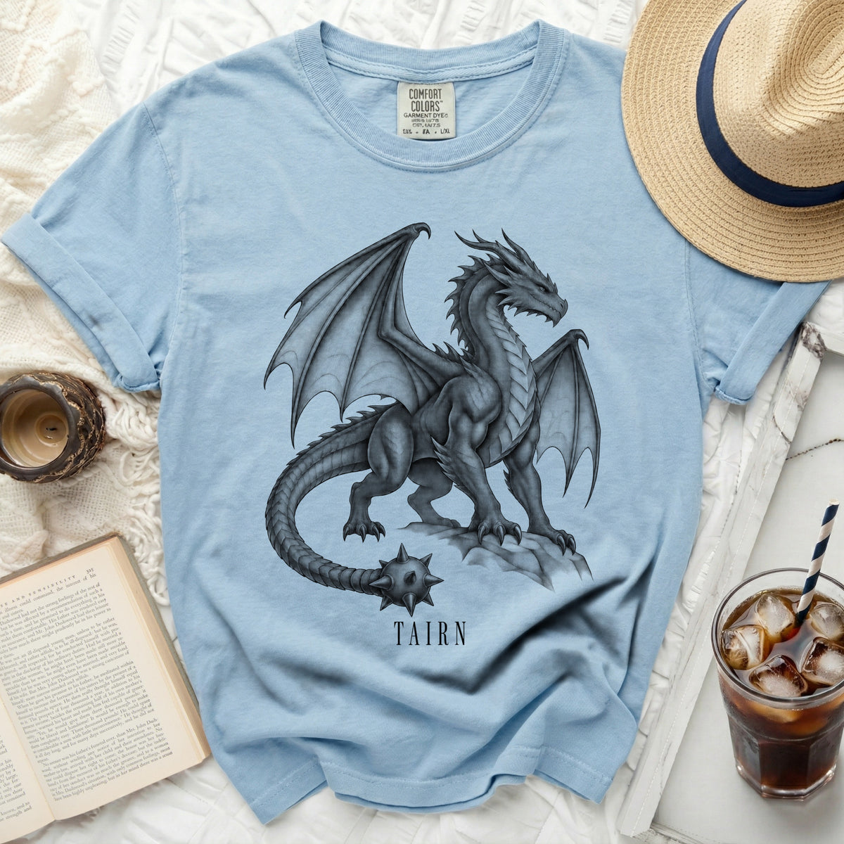 Light blue t-shirt with a detailed dragon graphic and the word TAIRN.