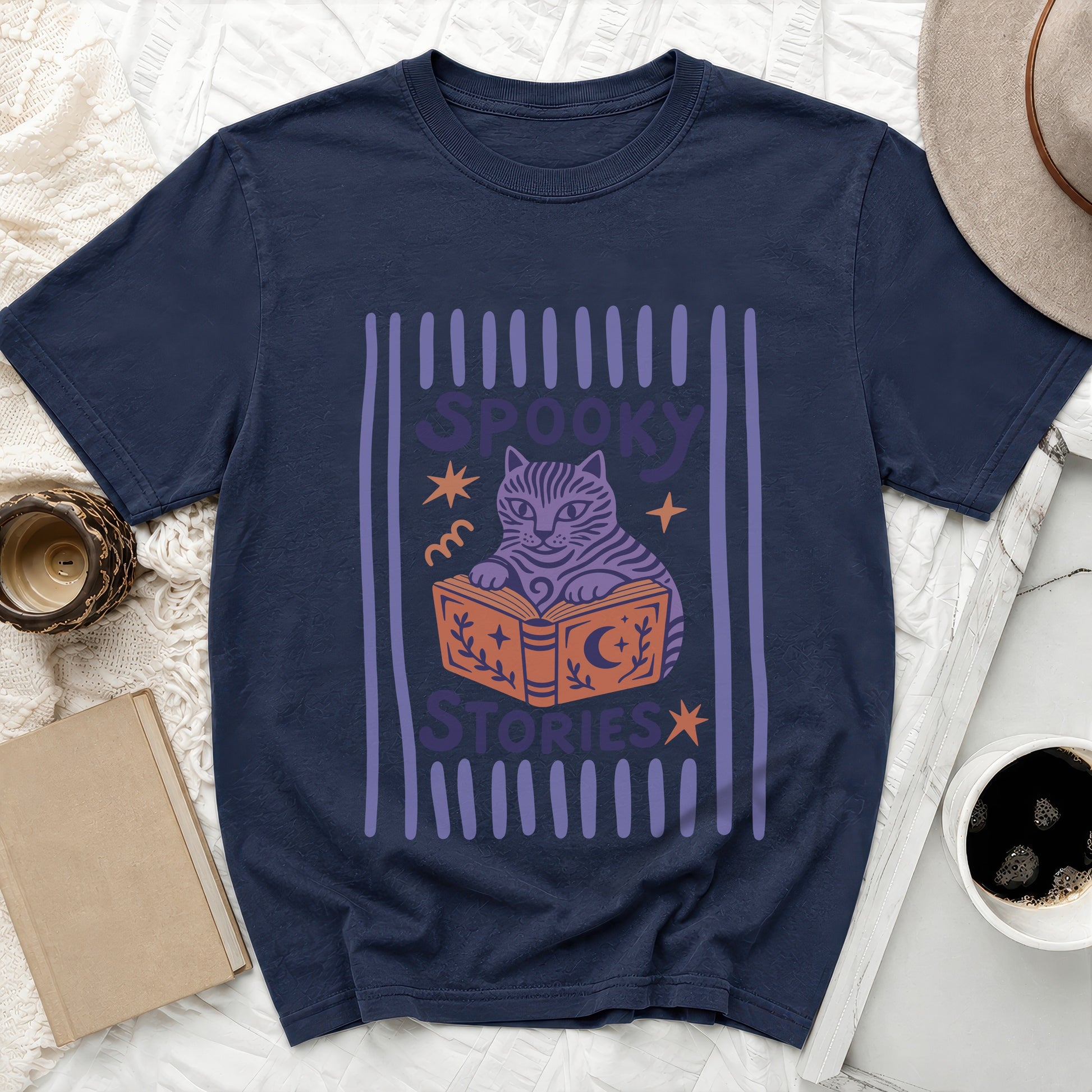 Navy t-shirt with a purple cat reading a book with text "Spooky Stories".