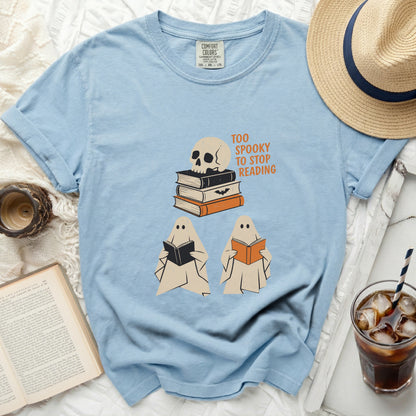 Light blue t-shirt with skull, books, and reading ghosts, "Too Spooky to Stop Reading" text.