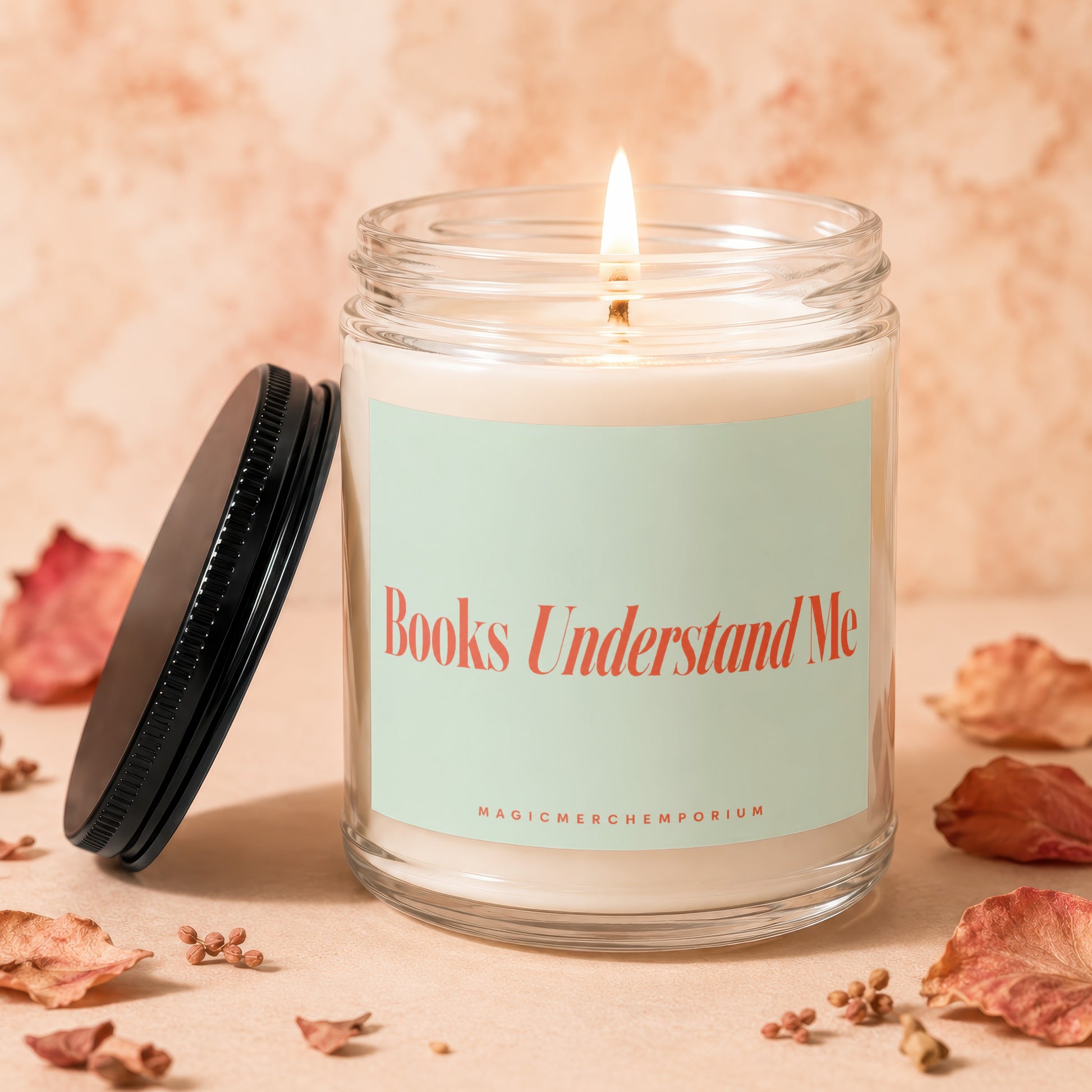 Glass candle with lit wick and "Books Understand Me" text