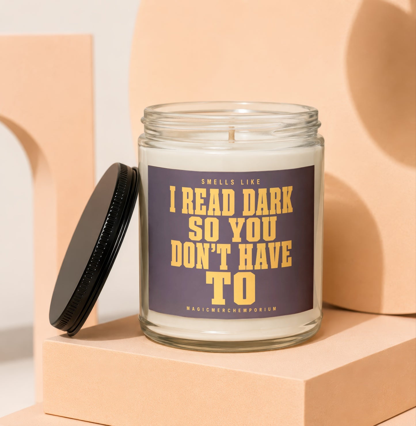 Glass candle with label reading "Smells like I read dark so you don't have to".
