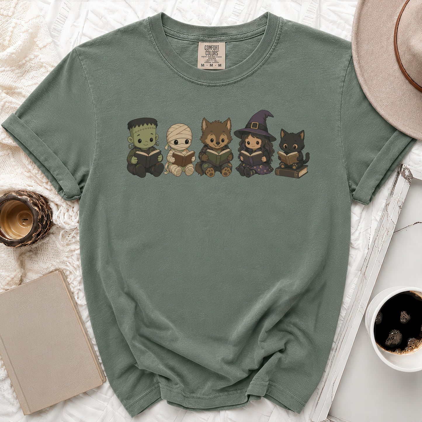Chibi Frankenstein, mummy, werewolf, witch, and cat characters reading books on a green shirt.