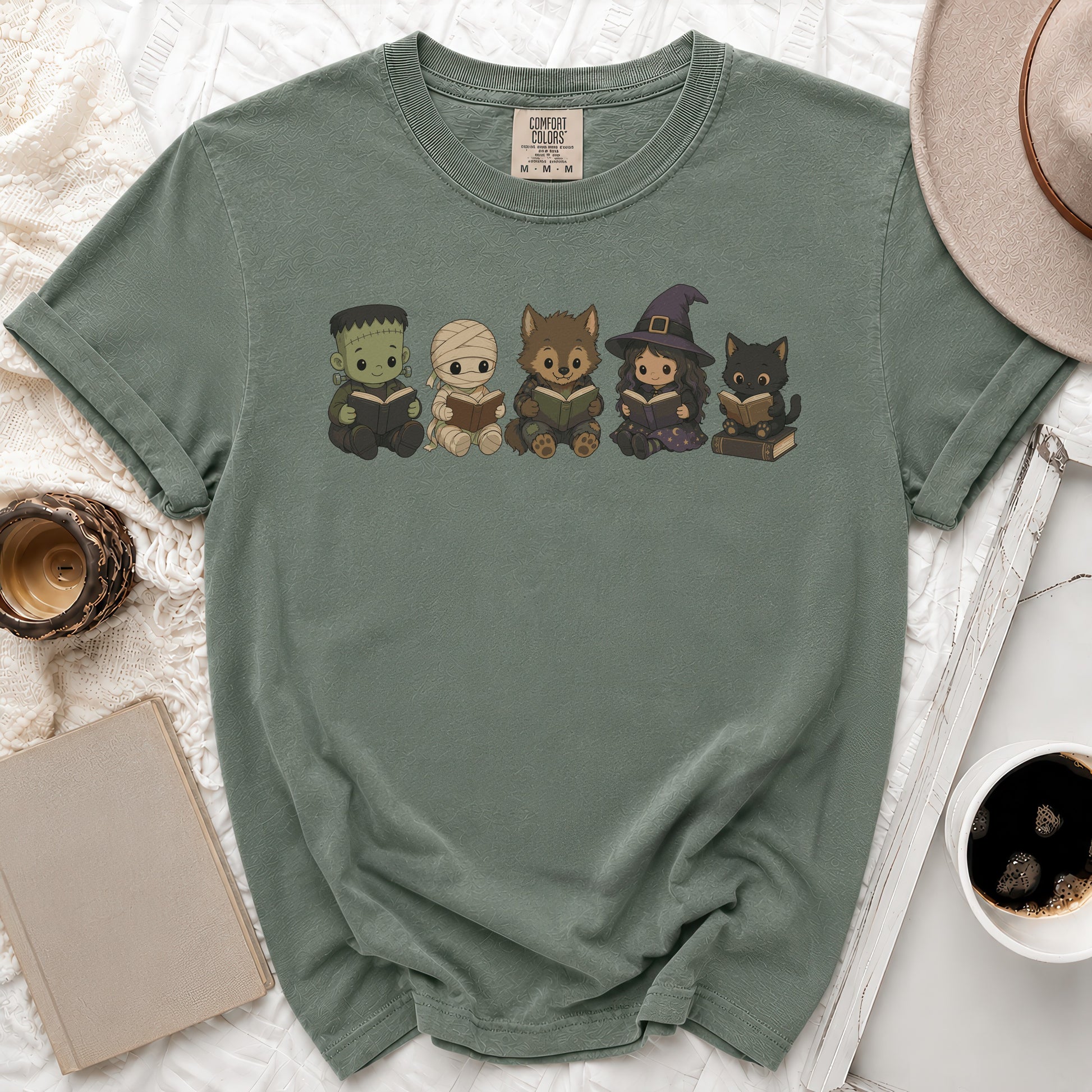 Chibi Frankenstein, mummy, werewolf, witch, and cat characters reading books on a green shirt.