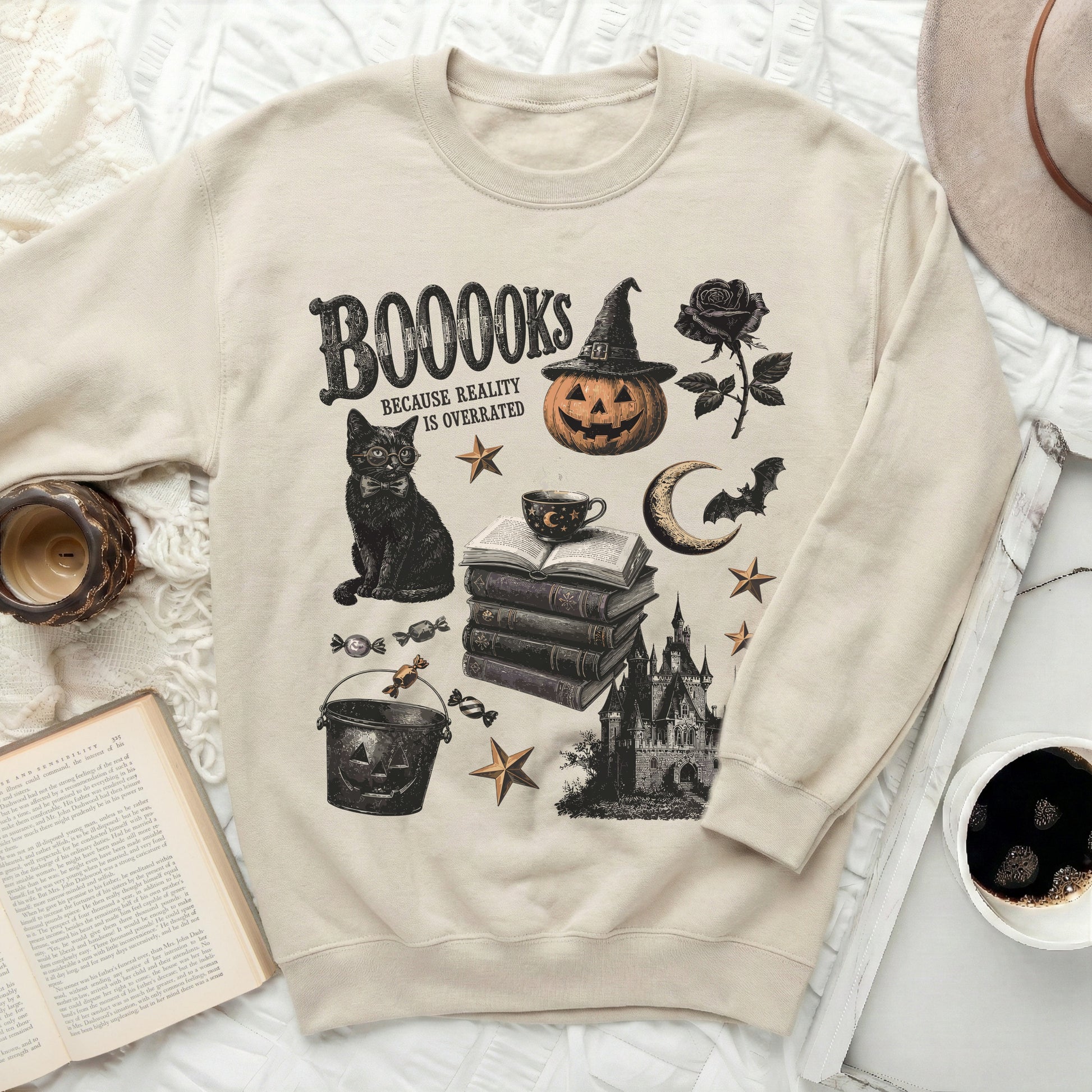Light beige sweatshirt with Halloween-themed print: books, cat, pumpkin, castle.