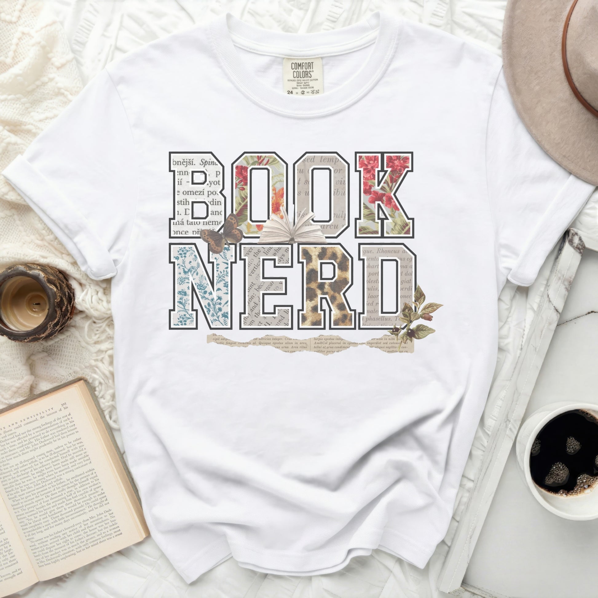 White t-shirt with "BOOK NERD" in floral and newspaper-print letters.