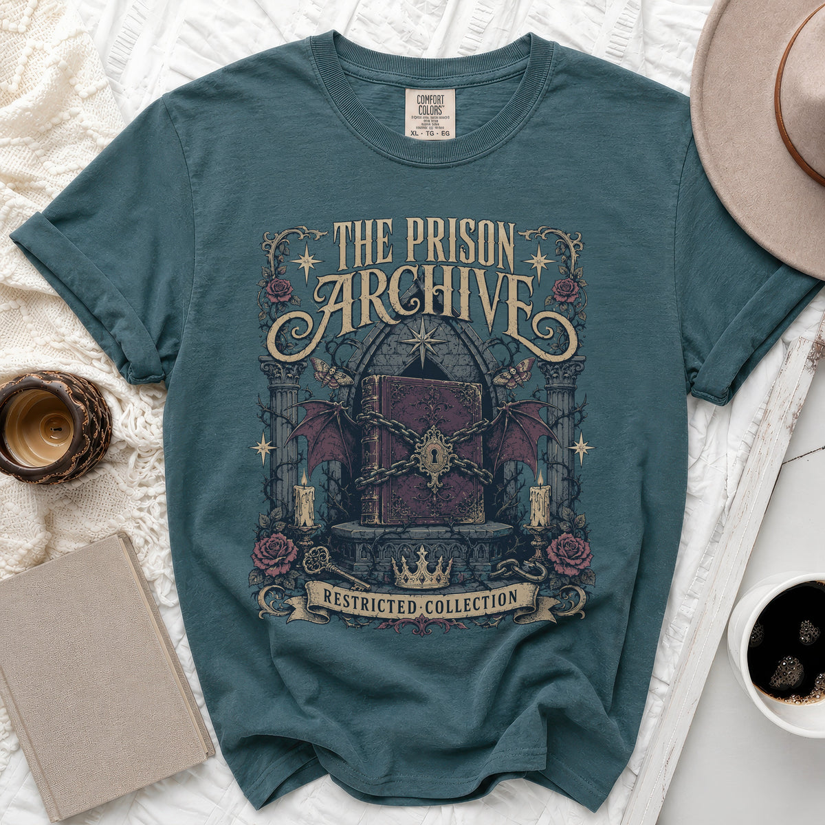 T-shirt graphic with chained book, bats, roses, and text "The Prison Archive Restricted Collection."