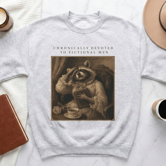 Light grey sweatshirt with "Chronically Devoted to Fictional Men" and raccoon in vintage style.