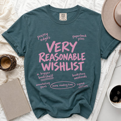 Dark teal t-shirt with pink text "VERY REASONABLE WISHLIST" and related phrases.