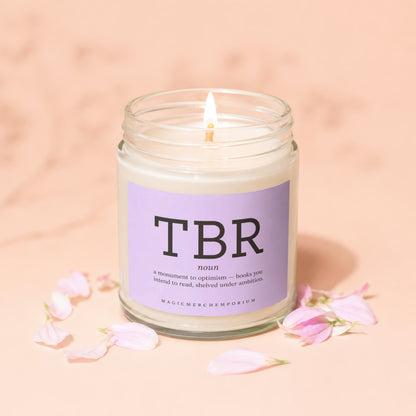 Candle with "TBR noun a monument to optimism" text on lavender label.