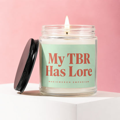 Candle with lit wick and black lid, reads "My TBR Has Lore"